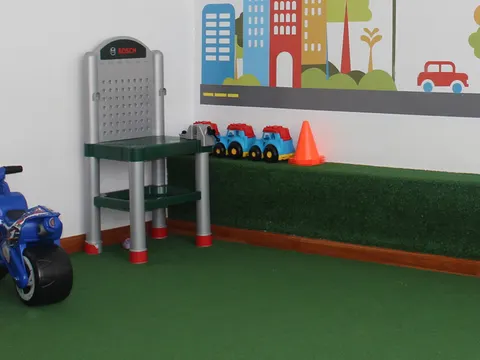 Área recreativa de Citykids con piso de grama sintética y triciclos