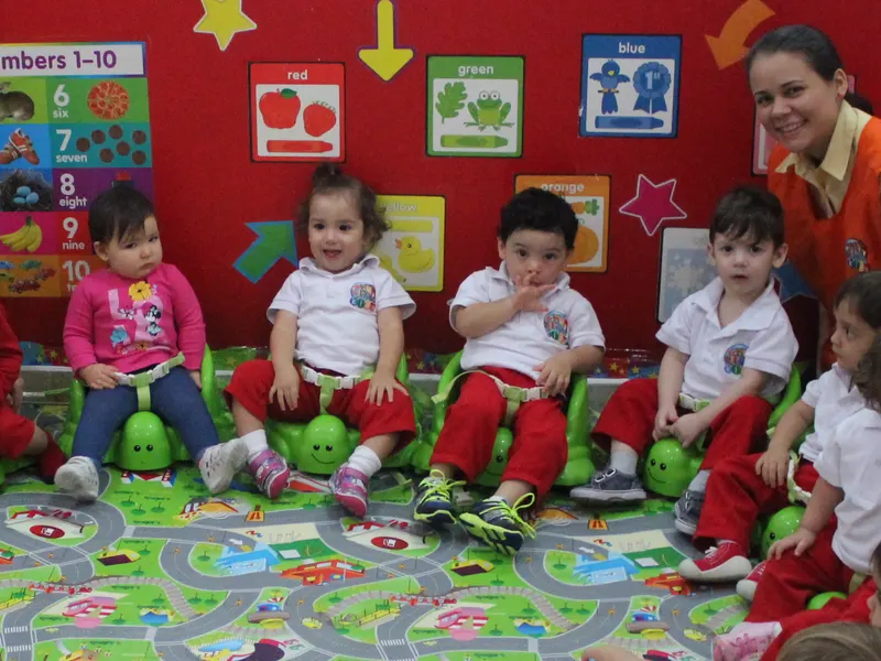 Teachers y niños sentados en círculo durante una actividad grupal