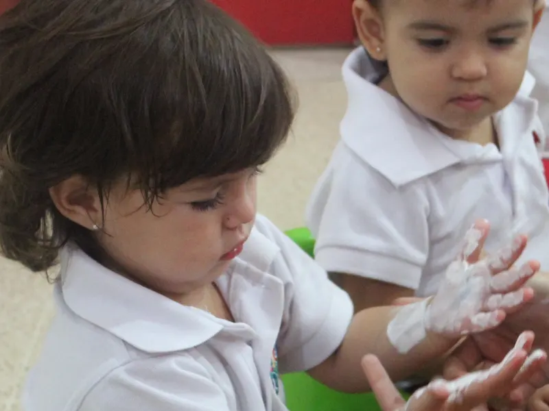 Teacher ayudando a un niño a lavarse las manos