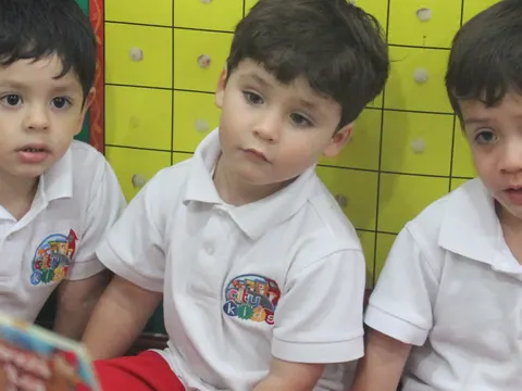Niños de la Sala Monkeys mirando un libro con su teacher