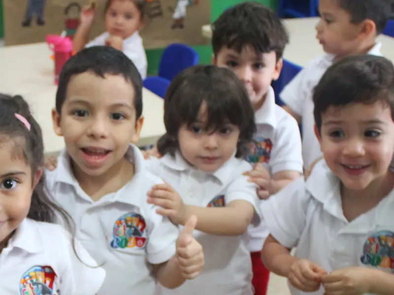 Niños sonriendo con su uniforme de Citykids en el salón de clases