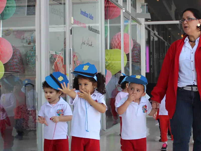Teacher guiando a niños disfrazados de policías en una actividad de profesiones