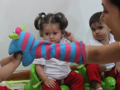 Teacher contando un cuento con títeres a un grupo de niños